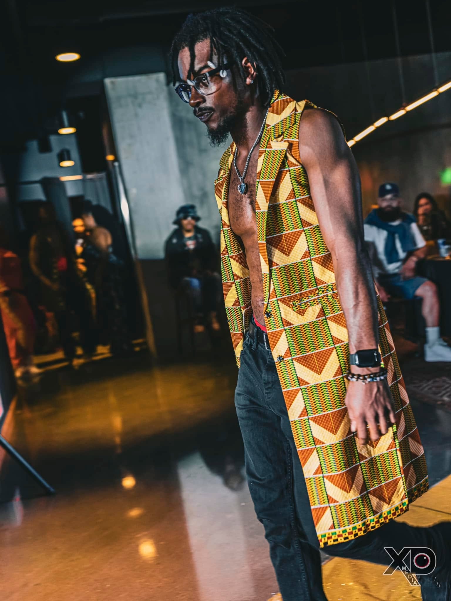 Man in kente cloth vest at fashion event