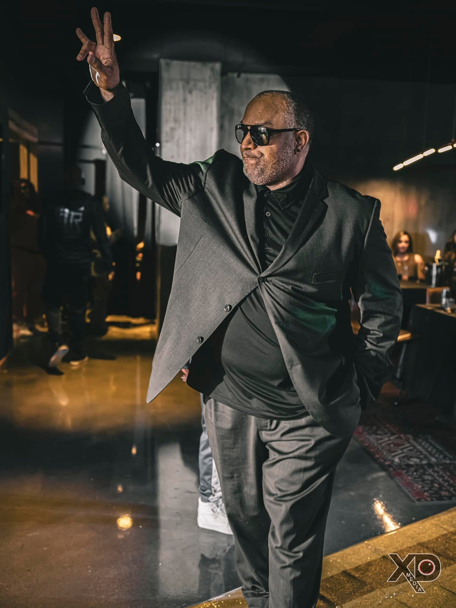 Man in gray suit and sunglasses at fashion show