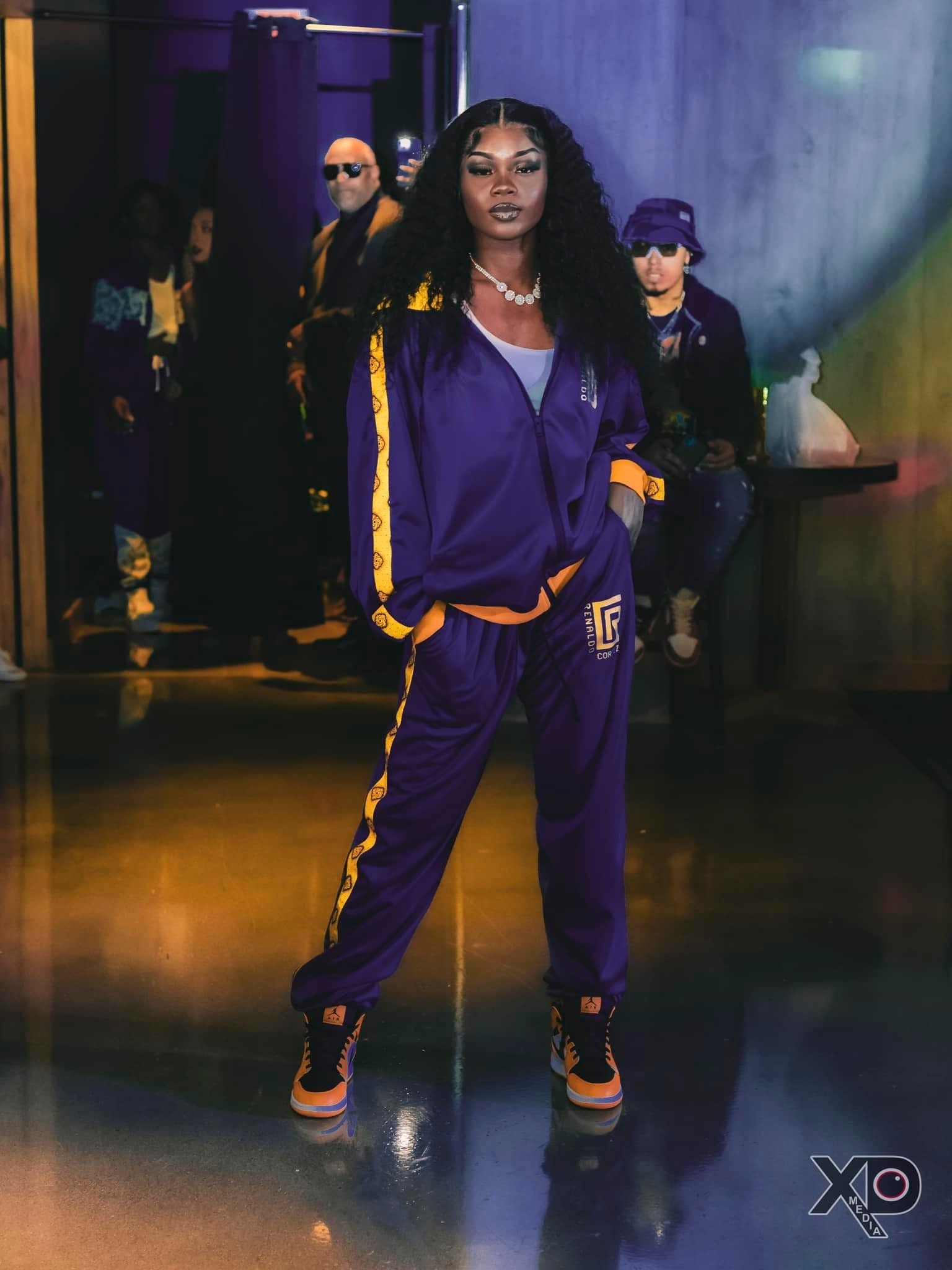 Woman in purple Renaldo Cortez tracksuit on runway