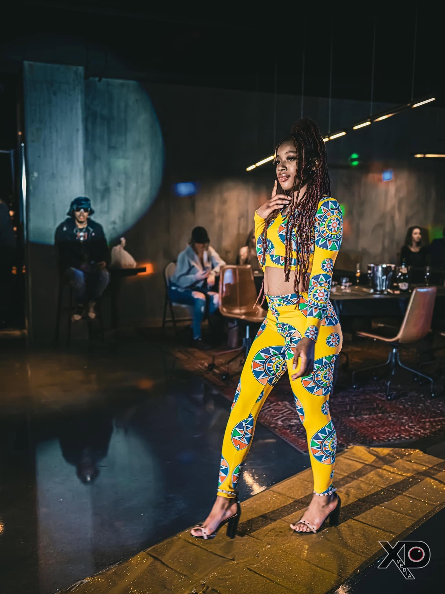 Woman in yellow African print outfit on runway