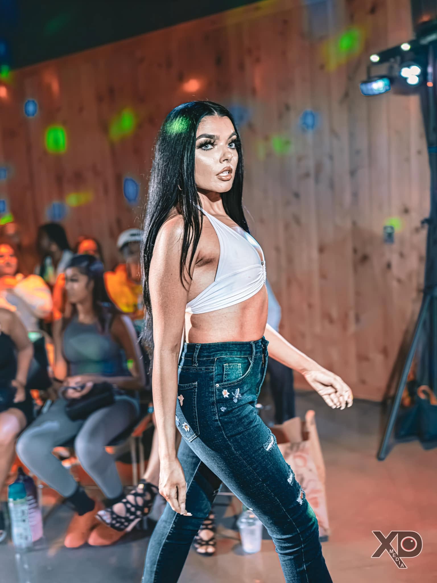 Model in white crop top and jeans on runway